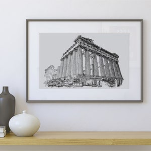 May include: Framed black and white architectural print of the Parthenon. The artwork features detailed line drawings of the ancient Greek temple, set against a light gray background. The print is displayed in a gray frame.