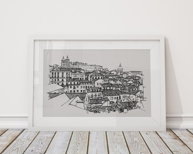May include: A black and white line drawing of a cityscape with buildings and a church in the background. The drawing is framed in a white frame and is hanging on a white wall.