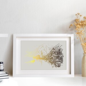 May include: A framed art print featuring a detailed pen and ink illustration of a mountain village scene. The artwork is primarily in black and white with gold accents, set against a light gray background. The print is displayed in a white frame.