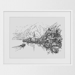 May include: Black and white pen and ink drawing of a lakeside village with a mountain backdrop. A boat is on the water, and the buildings reflect in the lake. The artwork is framed in a white border.