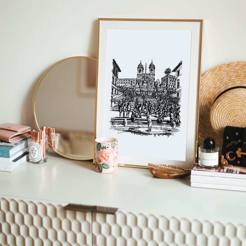 May include: Black and white line drawing of the Spanish Steps in Rome, Italy. The drawing is framed and hanging on a wall above a white dresser.