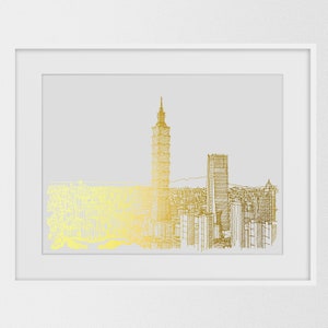 May include: A gold line drawing of a city skyline with a tall skyscraper in the center. The drawing is framed in a white frame and set against a light gray background.