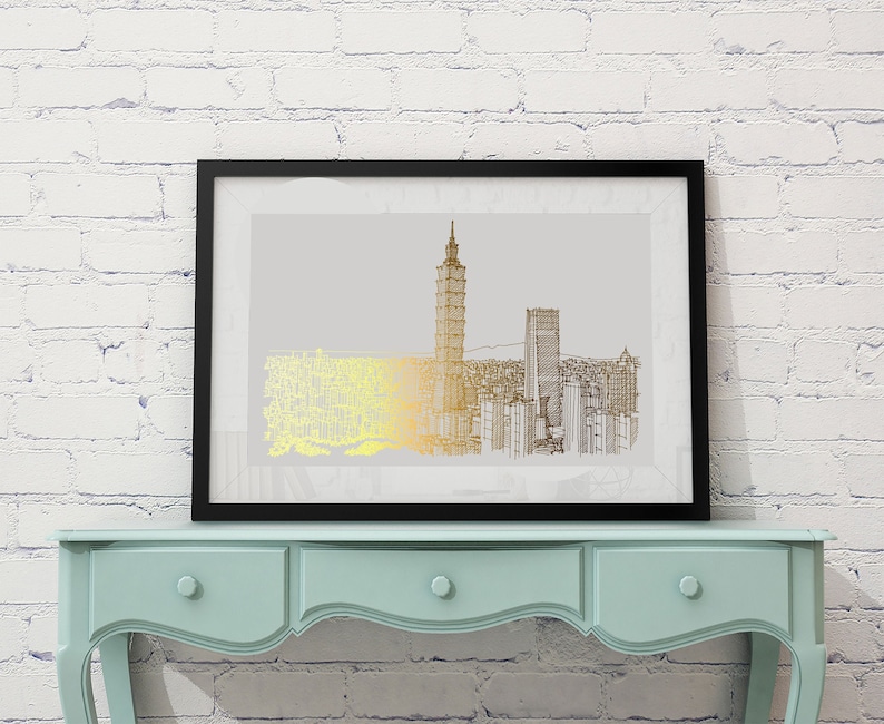 May include: A black framed print of a gold and black line drawing of a city skyline. The print is hanging on a white brick wall above a light blue dresser with three drawers.