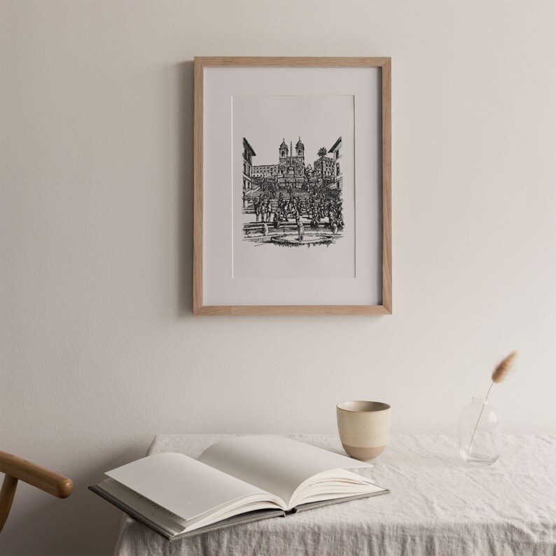 May include: A black and white line drawing of the Spanish Steps in Rome, Italy. The drawing is framed in a light wood frame and is hanging on a white wall.