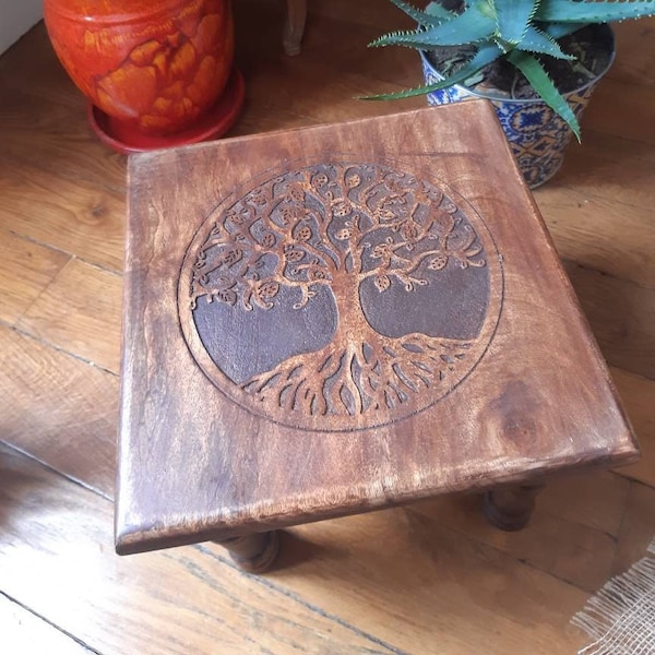 Wooden side table with tree of life symbol.