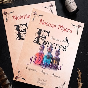 Peut inclure: Deux livres intitulés "Noémie Myara, Grimoire des Encres Magiques" avec des illustrations de flacons de potions colorées. Un flacon d'encre noire avec du texte est placé en haut à droite. Les livres ont des éléments floraux décoratifs.