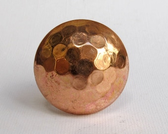 May include: A hammered copper knob with a round shape and a textured surface.