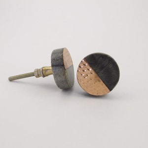 May include: Two round cabinet knobs with a gray stone and hammered copper design. One knob is shown with a screw.
