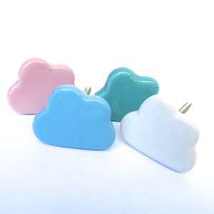 Peut inclure: Quatre boutons de porte en c&eacute;ramique en forme de nuage de couleur rose, bleu clair, turquoise et blanc.