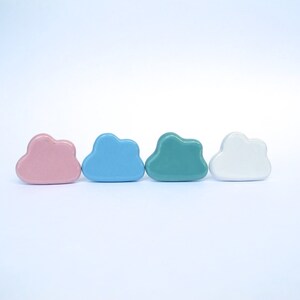 Peut inclure: Quatre ornements en forme de nuage en c&eacute;ramique de couleur rose, bleu clair, turquoise et blanc.