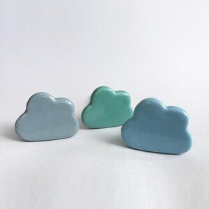 Peut inclure: Trois poign&eacute;es de tiroir en forme de nuage en c&eacute;ramique de couleur bleu clair, bleu sarcelle et bleu fonc&eacute;.