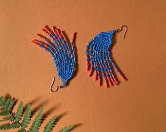 Long blue beaded earrings with orange at the ends of fringes. Long boho earrings for walking around.