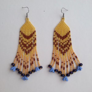 Long yellow beaded earrings with small blue flowers at the ends of fringes. Long boho earrings for bohemian wedding.