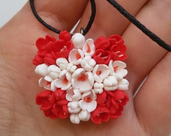 Handmade swiss national flag pendant cowered with hand sculpted flowers.