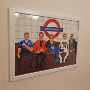 May include: A framed print of a band sitting on a subway platform. The sign above them reads "East Finchley". The band members are wearing sunglasses and casual clothing. One band member is wearing a white t-shirt with the words "Choose Life" printed on it.