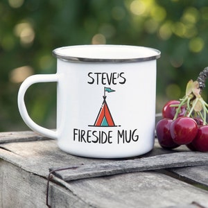 Può includere: Tazza da campeggio in smalto bianco con un motivo a tenda rosso e blu e il testo "Steve's Fireside Mug".