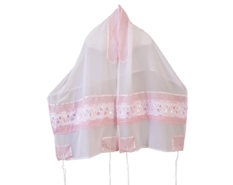 May include: A white prayer shawl with pink ribbon accents and floral embroidery. The shawl has a rectangular shape with a decorative border and corner squares. White tassels hang from the corners.