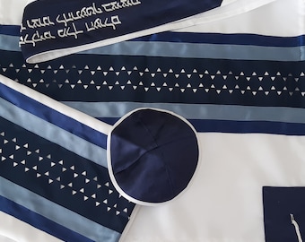 Puede incluir: Un chal de oración blanco con rayas azules y celeste y una kipá a juego. El chal presenta un patrón de pequeños triángulos blancos y texto en blanco. La kipá es azul marino con un ribete blanco.
