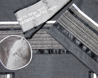 May include: A gray and black tallit set, including a prayer shawl and a kippah. The shawl features striped accents and embroidered Hebrew text. The kippah is a matching gray color. The set is made of a textured fabric.