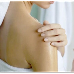 May include: A person's bare shoulder and upper arm with a hand resting on the shoulder. The skin is smooth and appears to be moisturized.