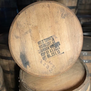K&ouml;nnte beinhalten: Ein Holzfass mit dem Text "WILD TURKEY DISTILLERY CO. BOURBON WHISKY DSP KY 67-RC3 LOT NO.15E13" auf der Oberseite.