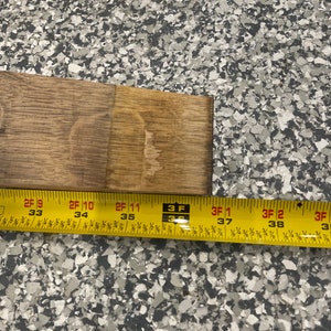 May include: Close-up of a yellow measuring tape with black markings. The tape reads "2F 9 33", "2F 10 34", "2F 11 35", "3 F 3", "3F 1 37", "3F 2 38", and "3F 3".
