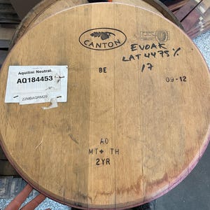May include: A wooden barrel with the text "CANTON" and "EVOAK LAT 4475% 17" written on it. The barrel is labelled with the text "Aquilini Neutral AQ184453 22MBAQRM29" and "BE 40 MT TH 2YR".