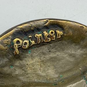 Op de afbeelding: Close-up van een messing object met het woord "Painter" in gouden letters.