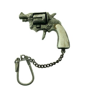 Puede incluir: Un llavero de juguete de revólver plateado con un mango de plástico blanco. El llavero tiene la palabra "TRUENO" grabada en el lateral. El llavero está unido a una cadena plateada.