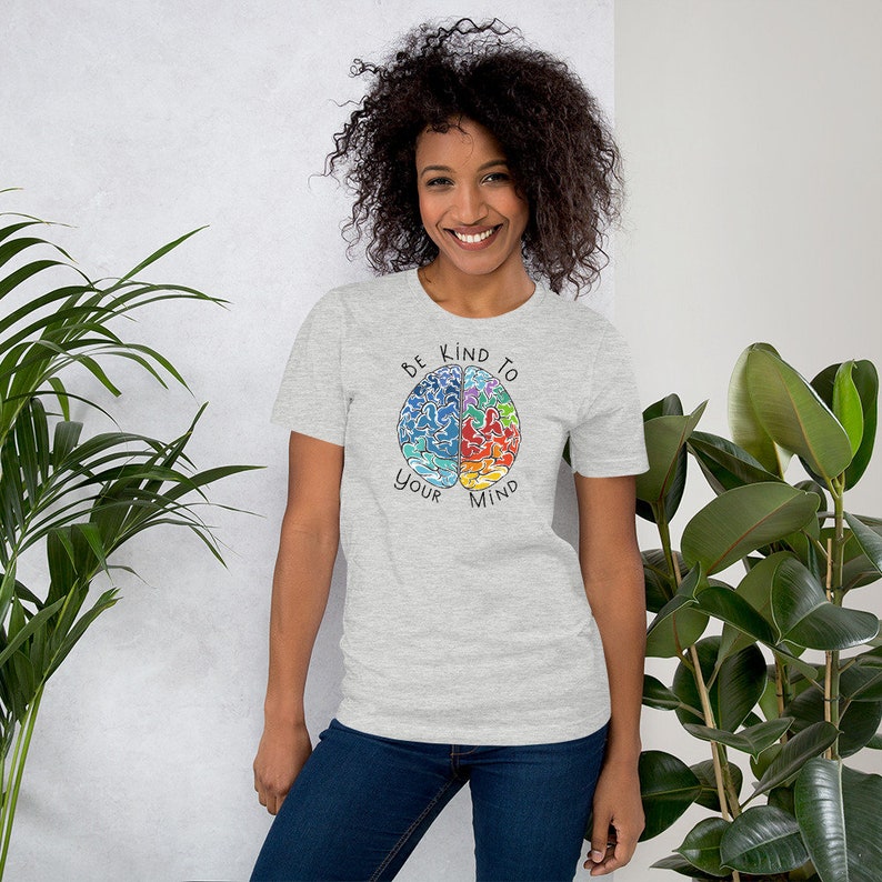 May include: A heather grey t-shirt with a colorful brain graphic and the text "Be Kind To Your Mind".
