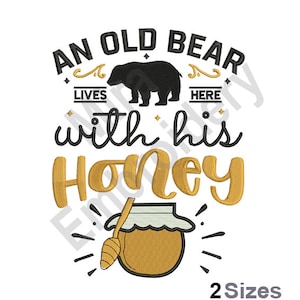 May include: An embroidery design featuring a black bear with the text "An old bear lives here with his honey" and a honey pot with a dipper.