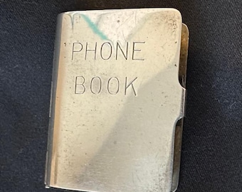 Guía telefónica antigua en plata de ley 'Charm' de la empresa Napier, década de 1950