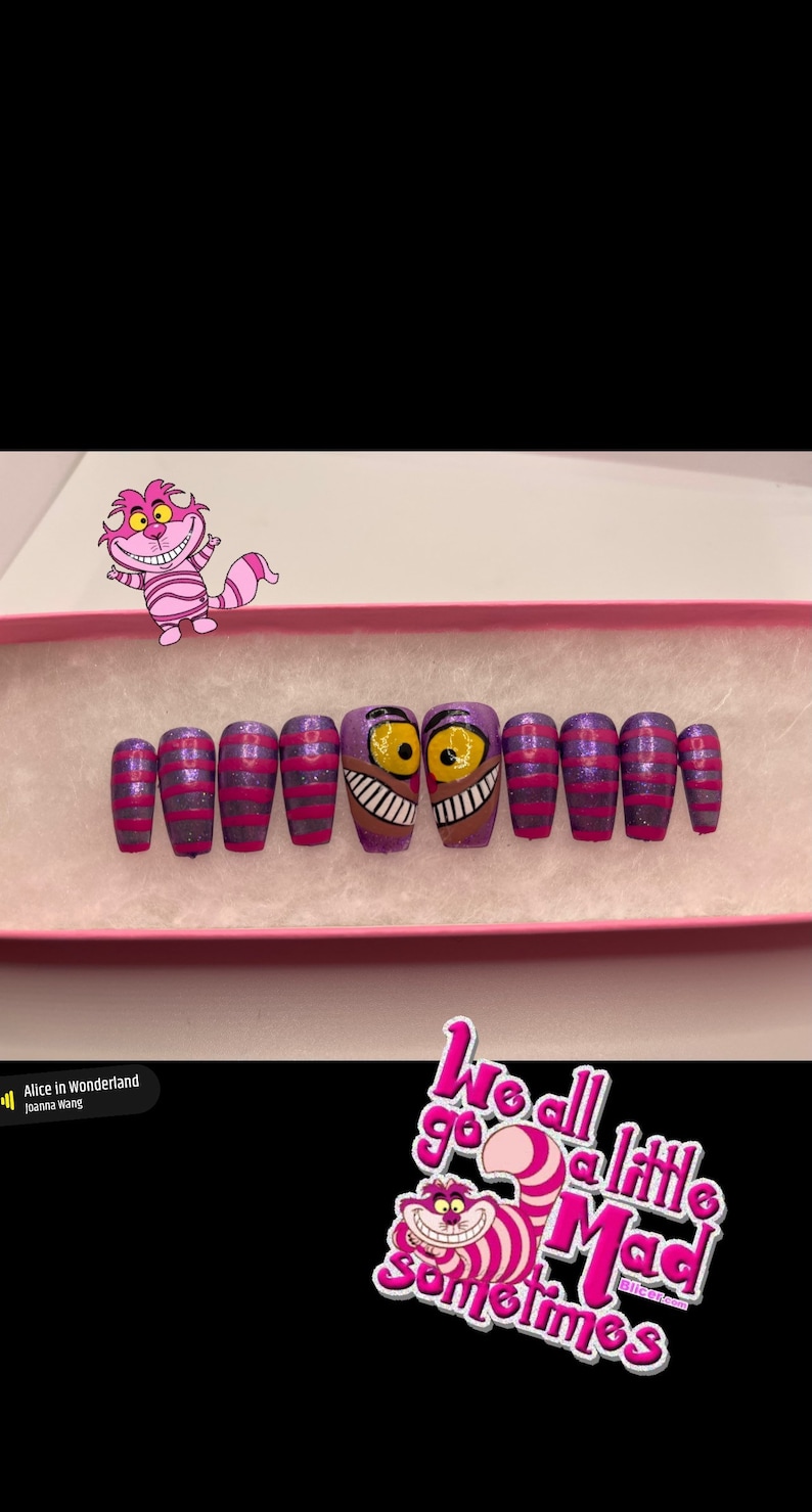 K&ouml;nnte beinhalten: Ein Set aus aufklebbaren N&auml;geln mit einem lila-rosa gestreiften Design, wobei zwei N&auml;gel das Gesicht der Grinsekatze aus Alice im Wunderland zeigen. Die N&auml;gel befinden sich in einer rosa Schachtel, mit einem Aufkleber mit der Aufschrift "We all go a little mad sometimes."