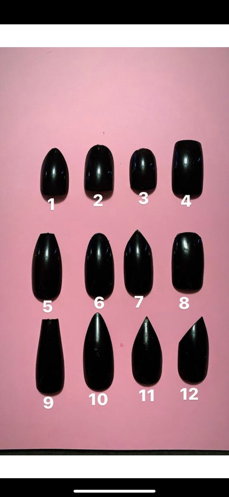 May include: A collection of twelve glossy black press-on nails in various shapes, including oval, almond, and square, arranged on a pink background. Each nail is numbered for easy selection.