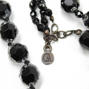 May include: A black beaded necklace with a silver charm that says "CA".