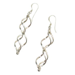 May include: A pair of silver spiral drop earrings. Each earring has a long, twisted design with a small ball at the bottom and a hook. The earrings are shown against a white background.