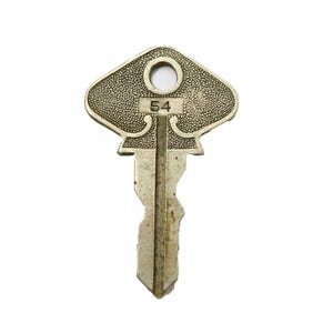 May include: A silver-toned key with a decorative, diamond-shaped head. The head has a small hole in the center and the number "54" is engraved on the front.