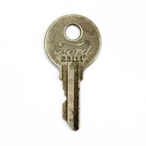 May include: A silver-toned Ford key with the word "Ford" and the number "23111" engraved on the head.