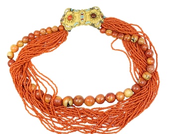 May include: An orange beaded necklace with a gold clasp. The necklace features multiple strands of small orange beads, interspersed with larger, round, speckled beads. The gold clasp is adorned with red, brown, and turquoise accents.