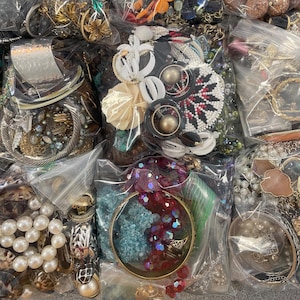 May include: A collection of various jewelry pieces, including bracelets, necklaces, and earrings, displayed in clear plastic bags. The jewelry features a variety of colors, materials, and styles, such as pearls, beads, and metal accents. The image showcases a diverse assortment of accessories.