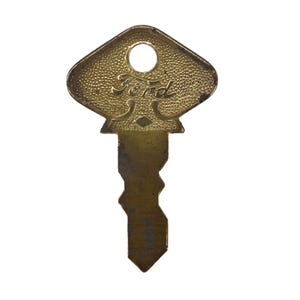 May include: A vintage brass key with the word "Ford" in a stylized script. The key has a diamond-shaped head with a textured surface and a circular hole. The key's blade has a unique, notched design.