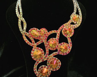 Könnte beinhalten: Eine zarte, mehrlagige Halskette mit einem floralen Design. Die Halskette besteht aus kleinen, schillernden Kristallen in Orange-, Rot- und Gelbtönen.