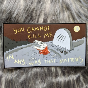 Könnte beinhalten: Eine Cartoon-Illustration eines Skeletts in einem Grab mit dem Text "You cannot kill me in any way that matters". Die Illustration ist vor einem braunen Hintergrund mit einem Mond und einem Grabstein platziert.