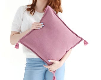 Funda de cojín de tejido liso texturizado de crepé rosa con borlas