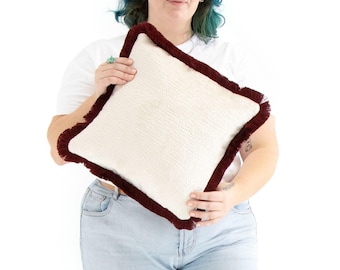 Funda de cojín hecha a mano en color rojo sangría con flecos de algodón