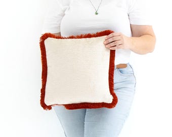 Funda de cojín hecha a mano en color rojo especia con flecos de algodón