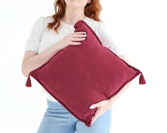 Funda de cojín texturizada de tejido liso con borlas en color rosa magenta