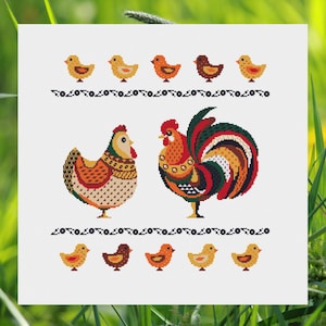 Puede incluir: Patrón de punto de cruz con un gallo y una gallina con pollitos. El gallo es rojo, verde, amarillo y naranja. La gallina es naranja, amarilla y marrón. Los pollitos son amarillos y naranjas.