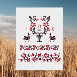 May include: A white cross-stitch embroidery design featuring a floral wreath with two roosters, a vase, and the letters J, O, K, and the year 2010.