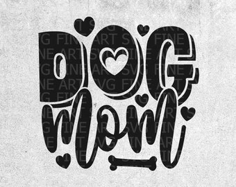 May include: A white t-shirt with a black and yellow graphic that says "Dog Mom" with a bone and pink hearts. The graphic is on a white t-shirt. The t-shirt is on a wooden surface.